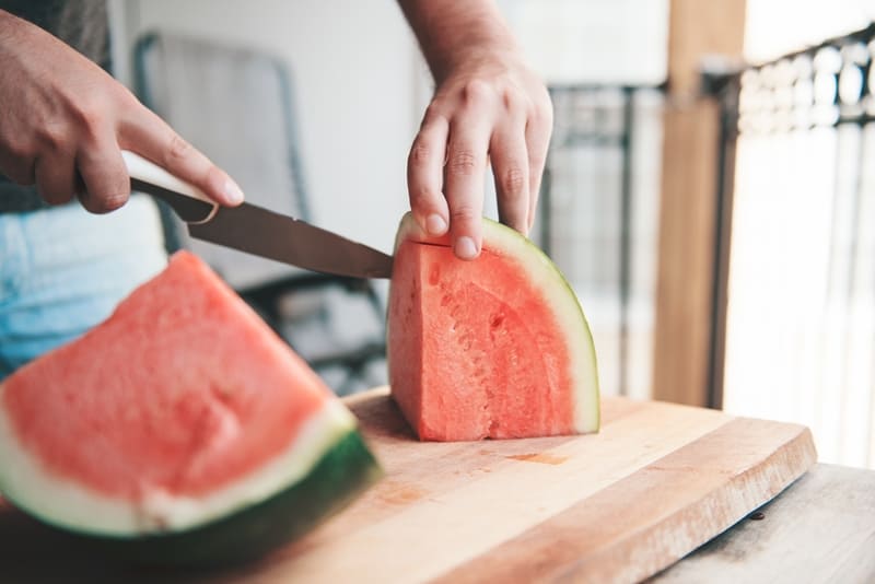 Man cutting watermelon. 